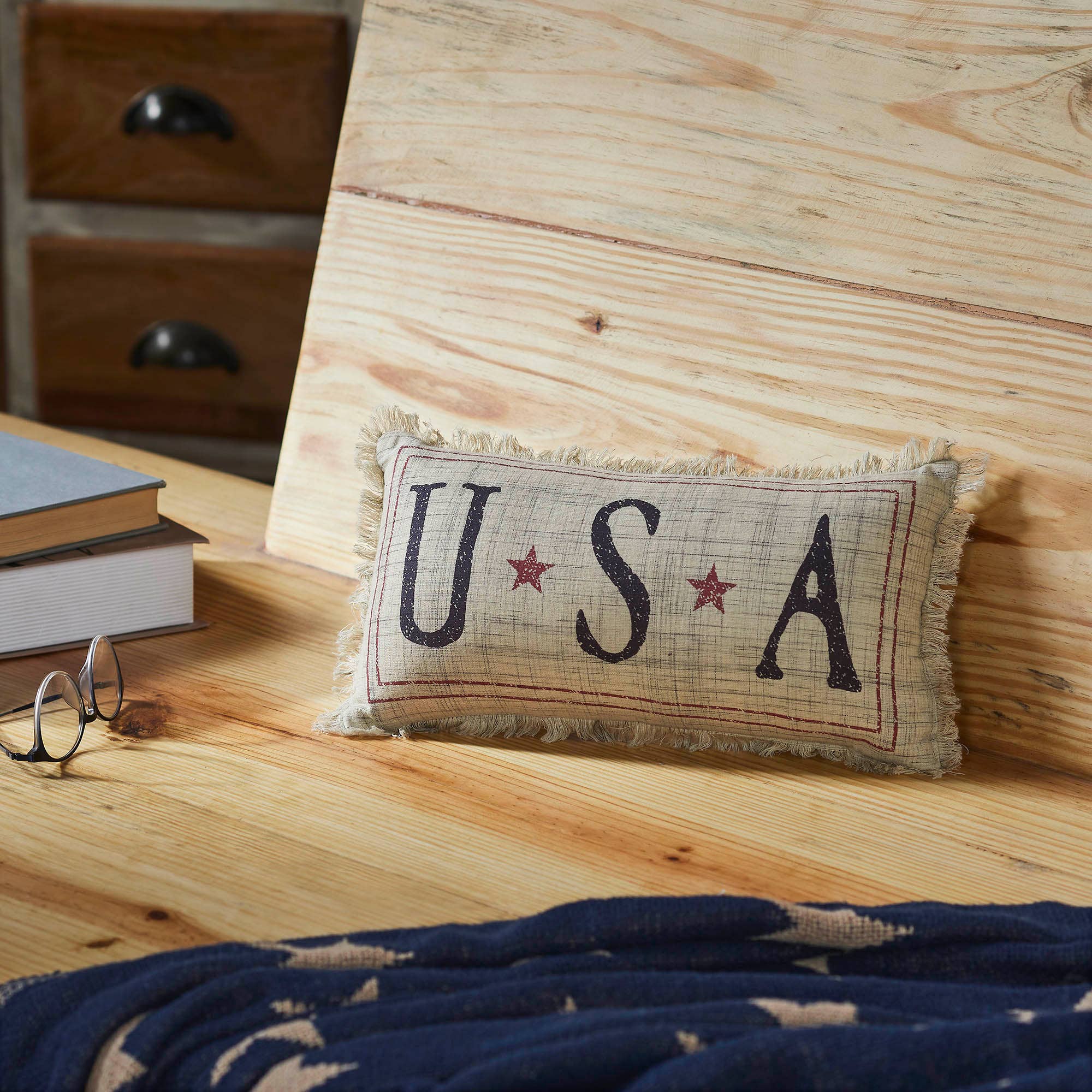 Small pillow with 'USA' text on a wooden surface