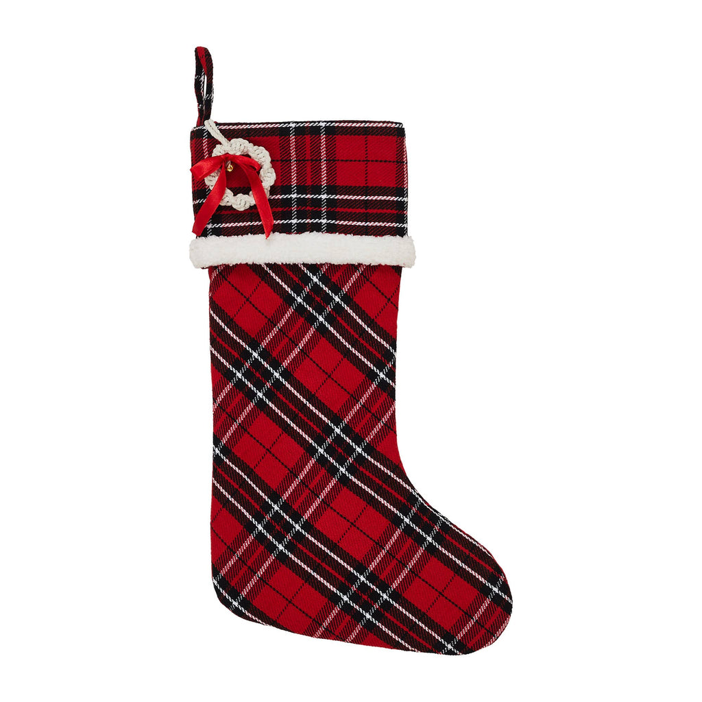 Red and black plaid Christmas stocking with a white bow on a white background