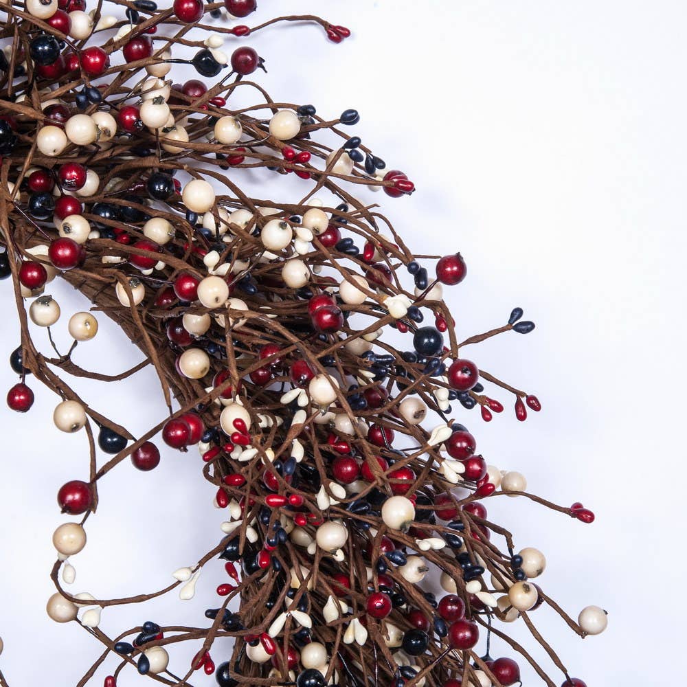 Decorative garland with red, white, and black berries on a white background