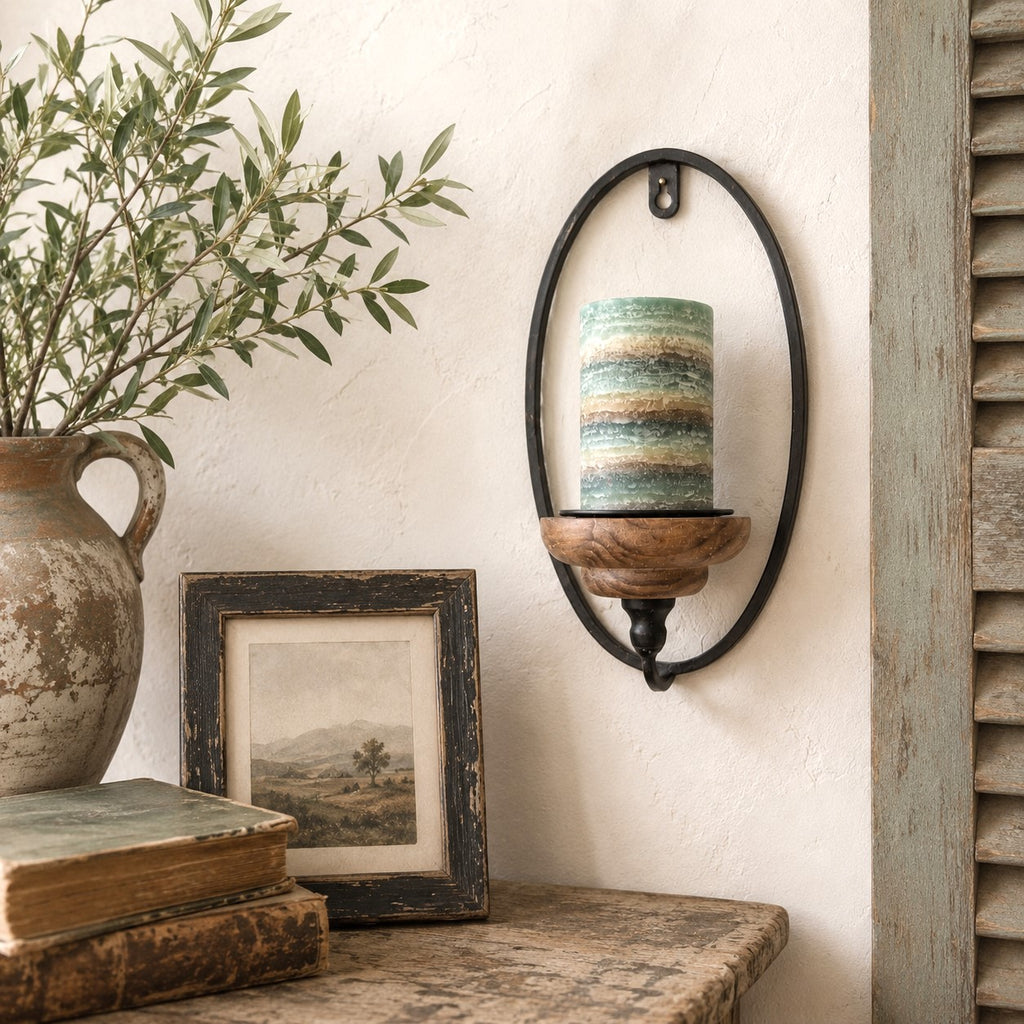 Decorative wall sconce with a candle, framed picture, and vase on a shelf.