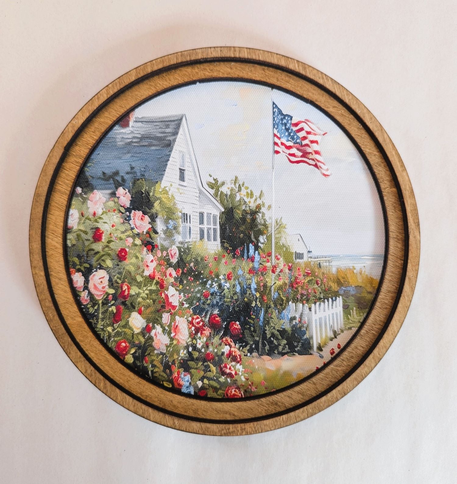Decorative wall art with a garden scene and American flag in a wooden frame.