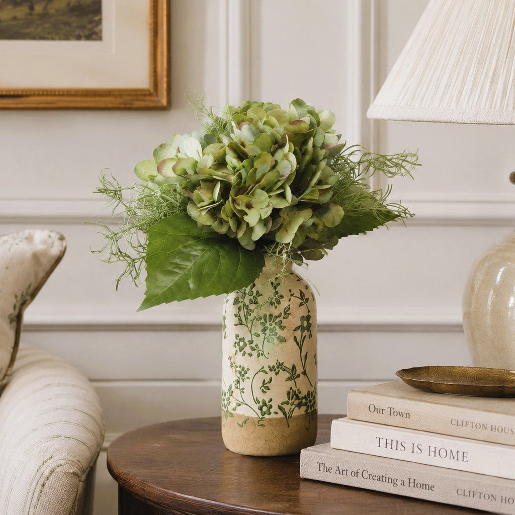 Vase with green hydrangea  flowers on a wooden table in a living room setting
