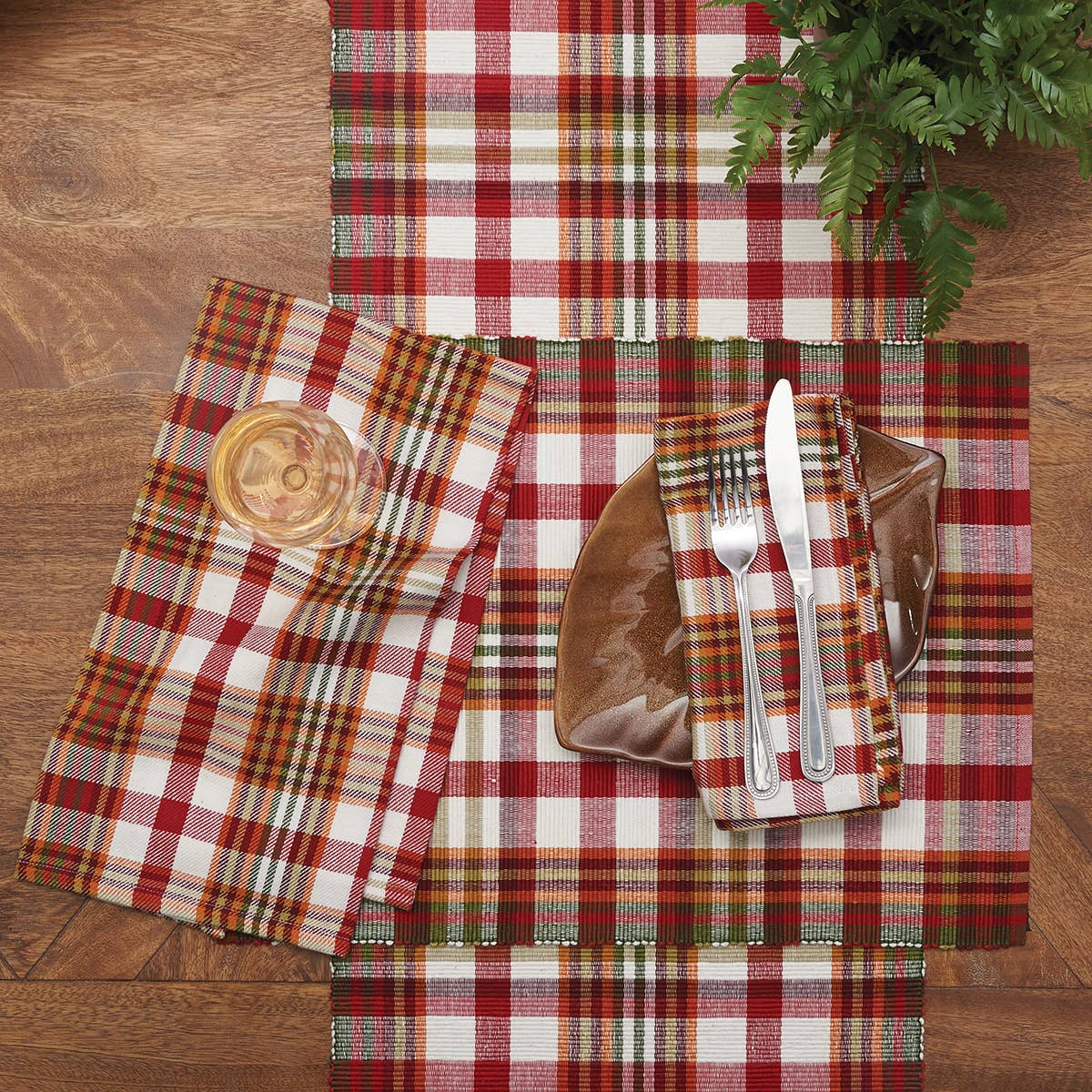 Plaid placemats, table runner, and napkin on a wooden surface